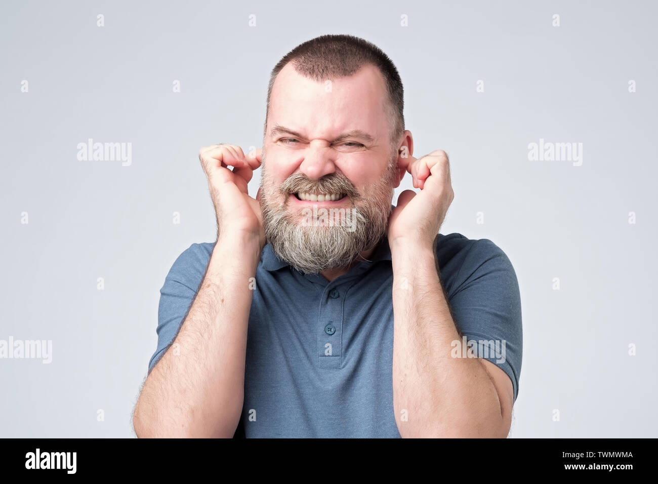 Annoyed caucasian man avoid hear bothering loud noise Stock Photo
