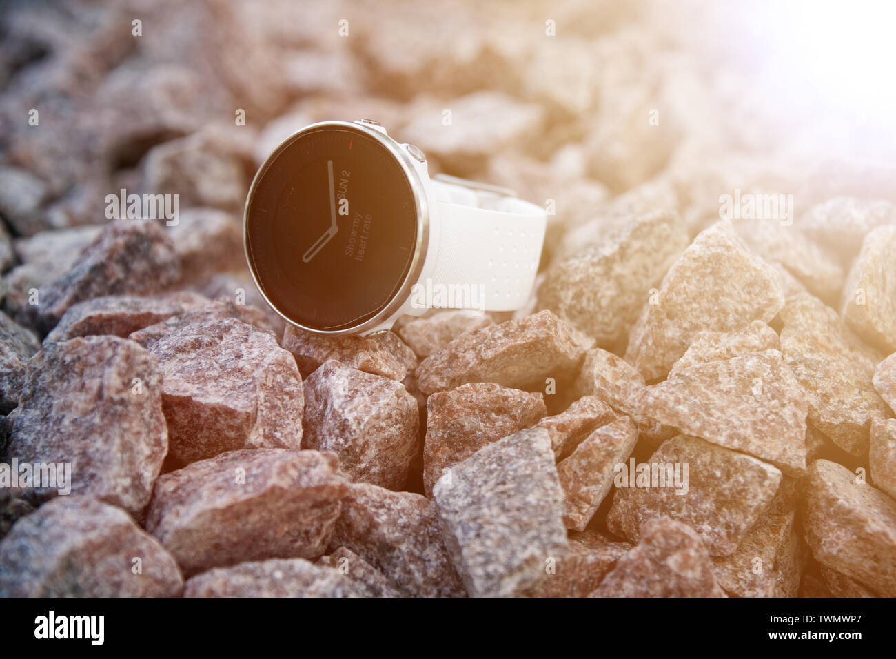 Sport watch for triathlon on the granite gravel. Smart watch for tracking daily activity and strength training. With words - Show my heart rate. Stock Photo