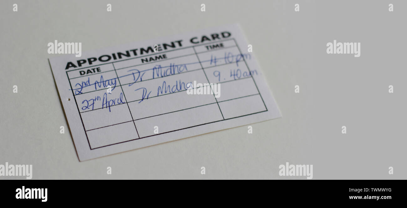 Closeup woman's hand holding visit card with doctor appointments. GP surgeryWales, United Kingdom, April 2019 Stock Photo