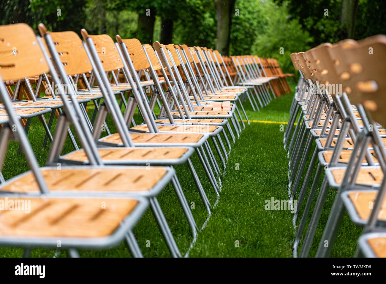 Wooden chairs closeup stand outside in the park in the rain. Empty