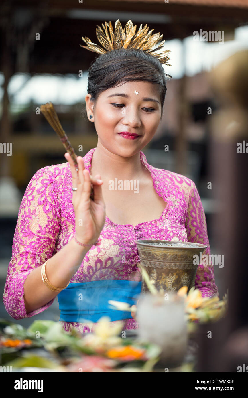 Young pretty woman in traditional ceremonial clothing praying at Hindu