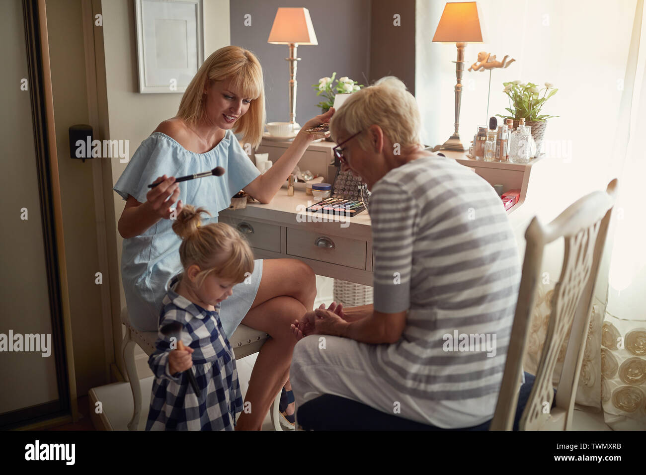Female child with mom and grandma having fun with make up Stock Photo ...