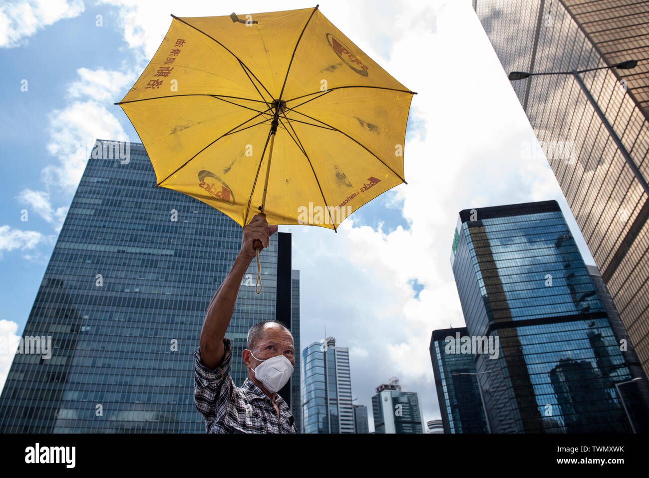 A protester holds a yellow umbrella, a symbol used during the Umbrella Movement, during the latest demonstration in Hong Kong. Despite the Chief Executive Carrie Lam's attempt to ease the heightened tension by agreeing to suspend the controversial extradition bill, student groups and union has continue the protest against Hong Kong government. The protesters called for the withdrawal of the controversial extradition bill, the release and non-prosecution of the people arrested due to the cause, investigation of whether excessive force had been used by the police on June 12, and the resignation Stock Photo