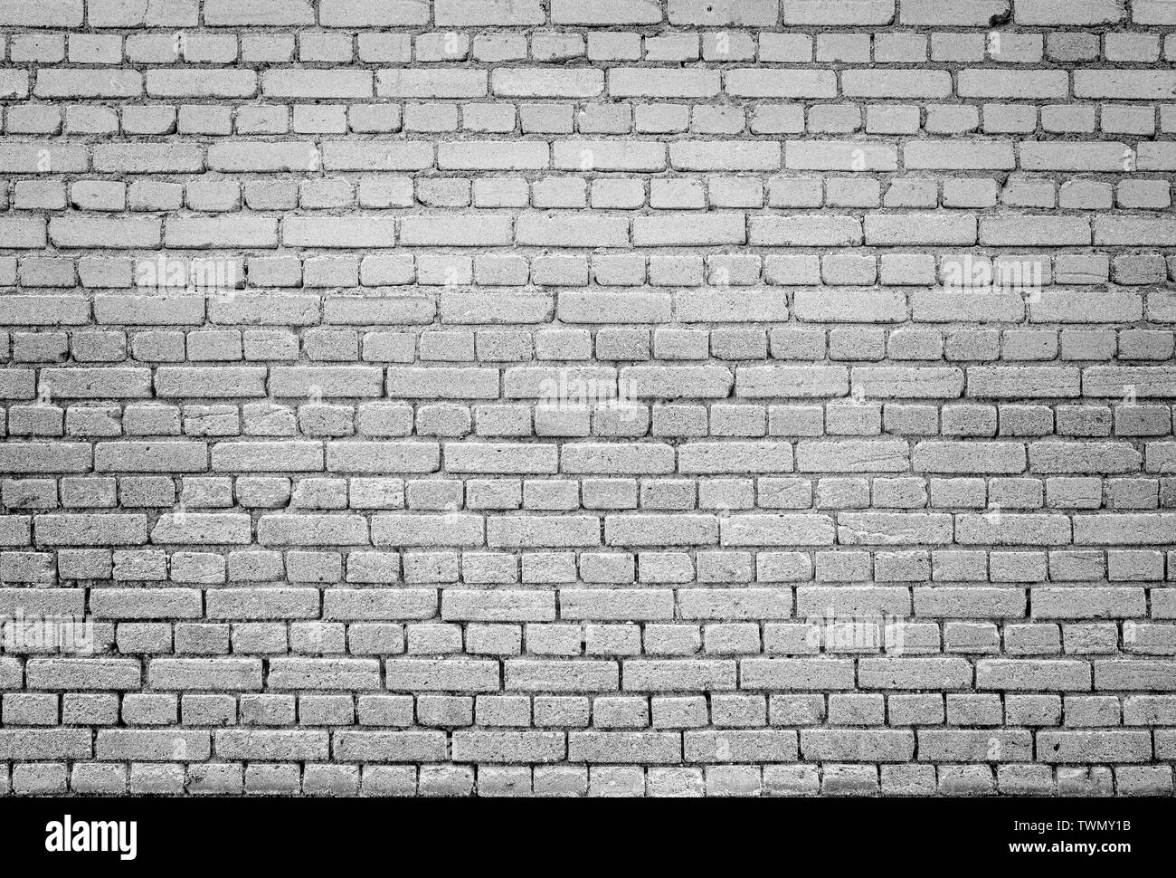 High resolution full frame background of detailed old brick wall in black and white with vignetting. Stock Photo