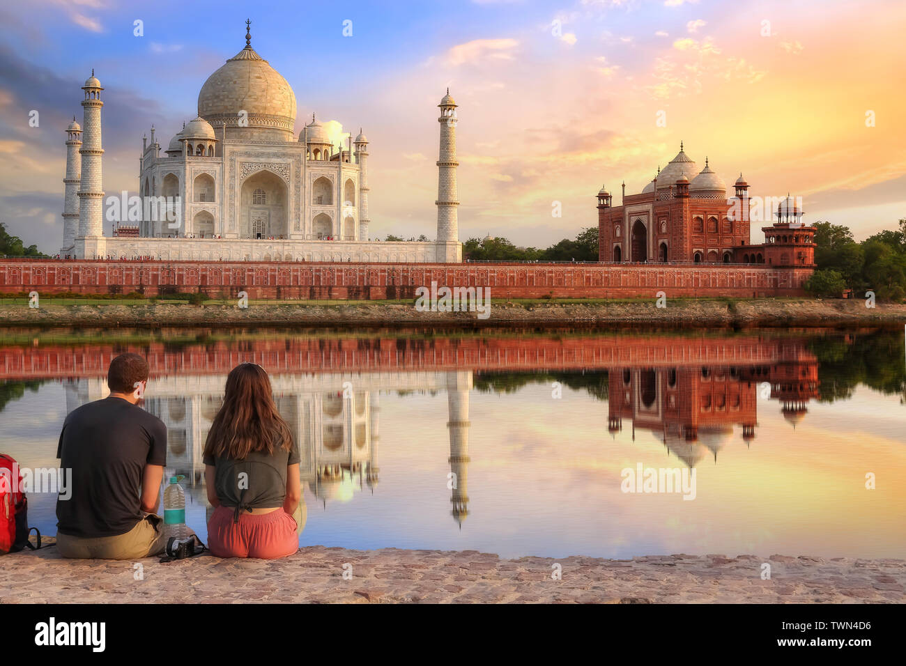 Taj Mahal sunset view from Mehtab Bagh on the banks of river Yamuna with a tourist couple enjoying a romantic moment. Stock Photo