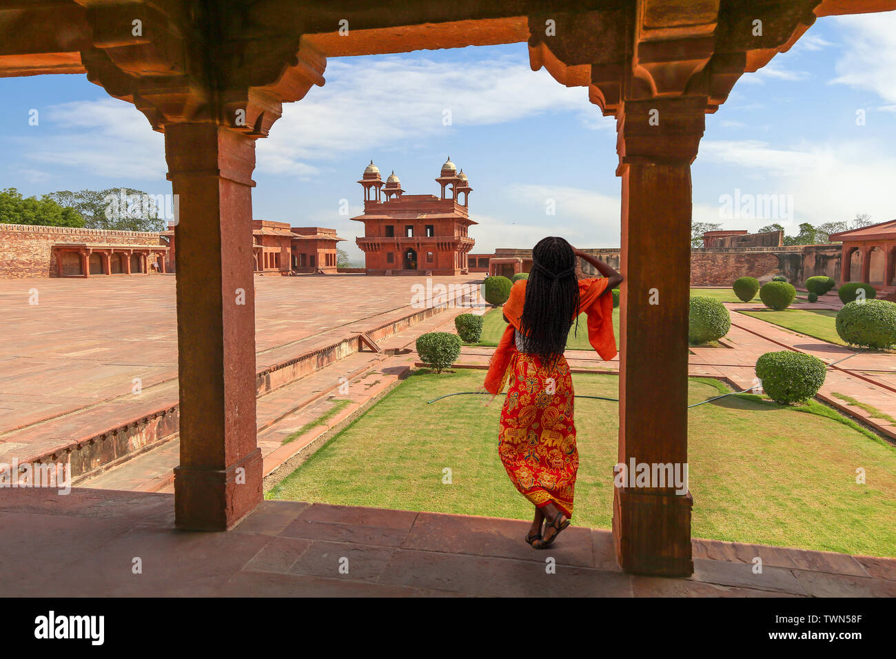 Fatehpur Sikri red sandstone architecture with view of woman tourist posing at the ancient fort city at Agra India Stock Photo