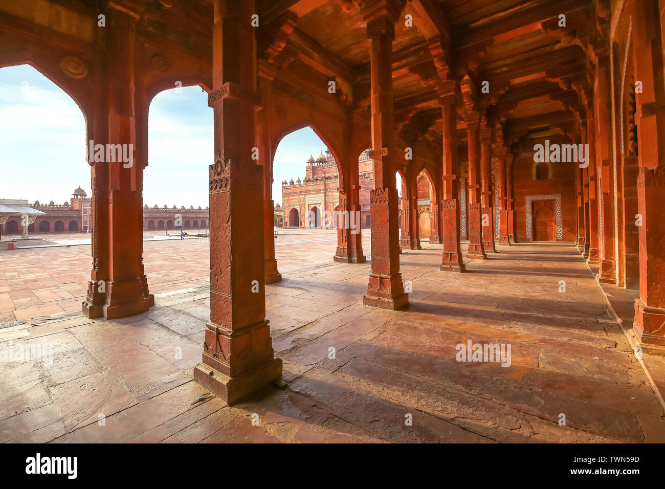 Fatehpur Sikri red sandstone architecture structure with view of columns and largest Indian mughal architecture gateway known as the 'Buland Darwaza'. Stock Photo