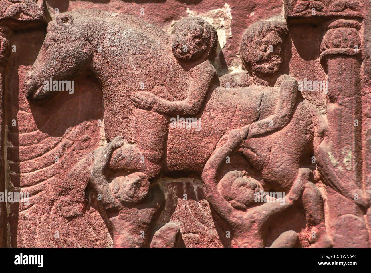 Archaeological red sandstone pillar carvings depicting ancient horseman and warriors Stock Photo