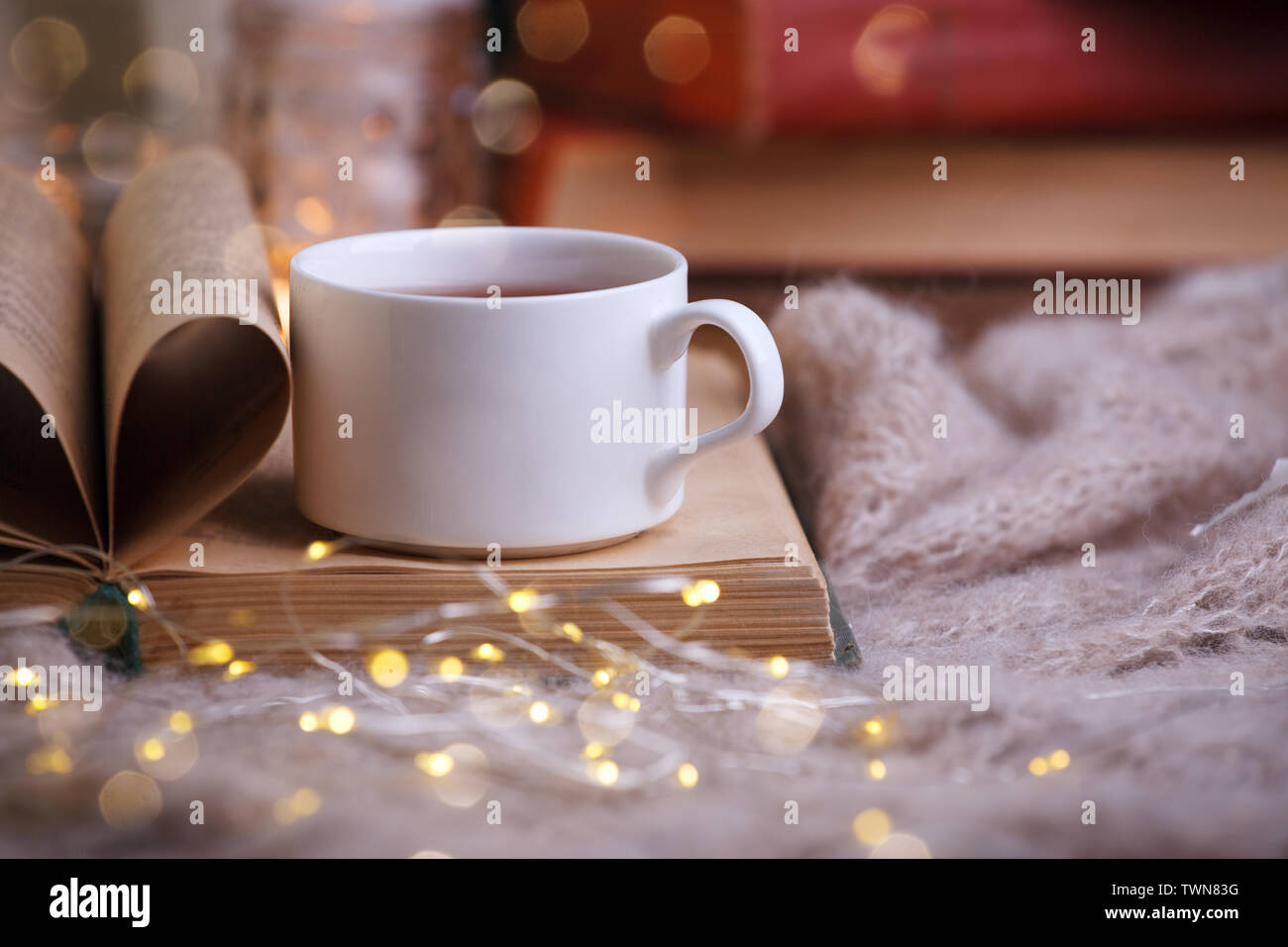 still life a cup of tea with an open book on a wooden table, the concept of cosiness and reading, Cozy autumn winter leisure time Stock Photo