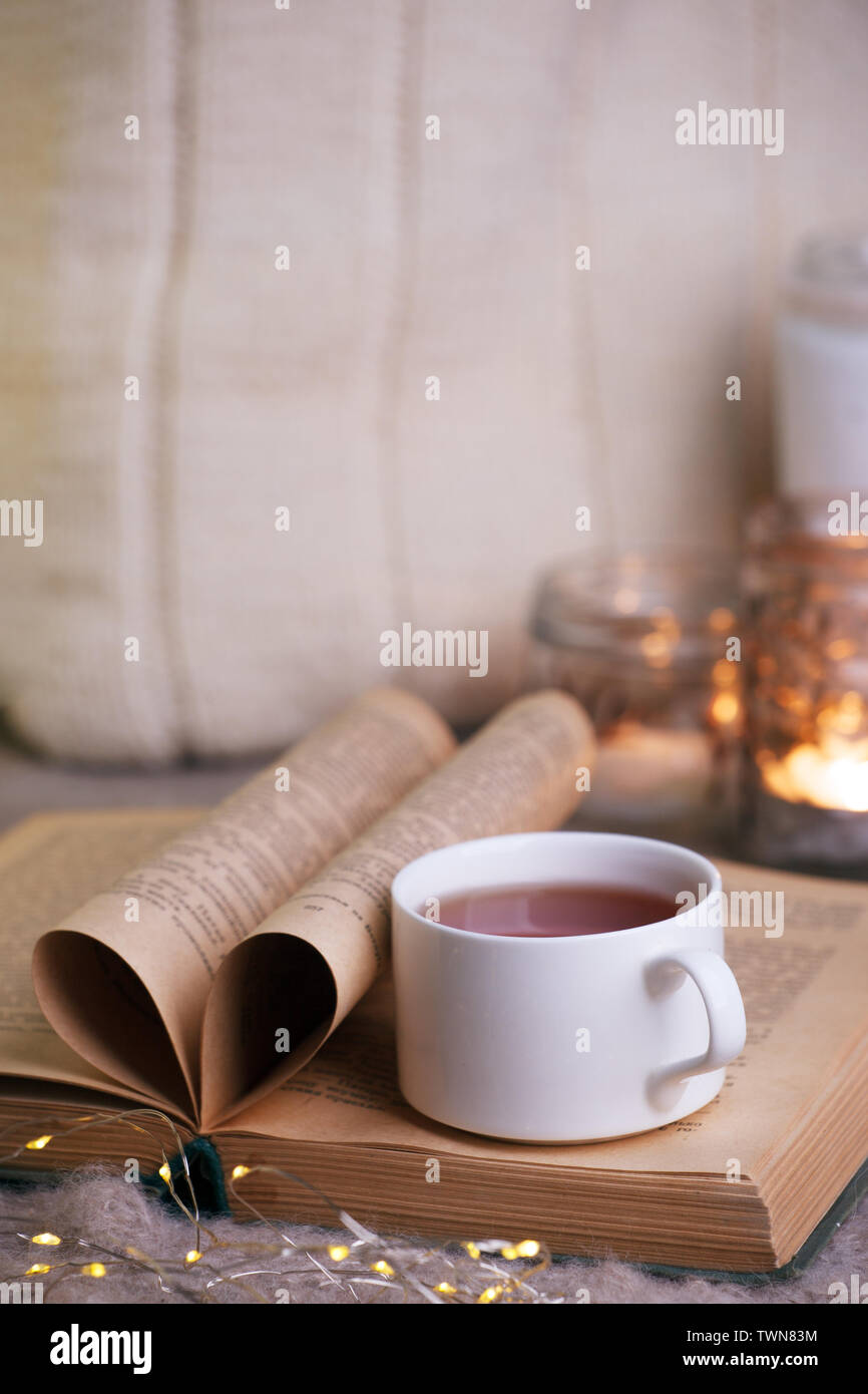 still life a cup of tea with an open book on a wooden table, the concept of cosiness and reading, Cozy autumn winter leisure time Stock Photo