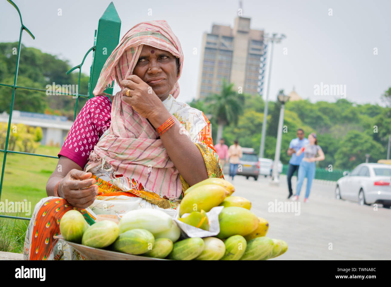 Bangalore, Karnataka India-June 04 2019 :Street vendor Woman selling mango's and cucumber at hot sunny day at Bangalore, India Stock Photo