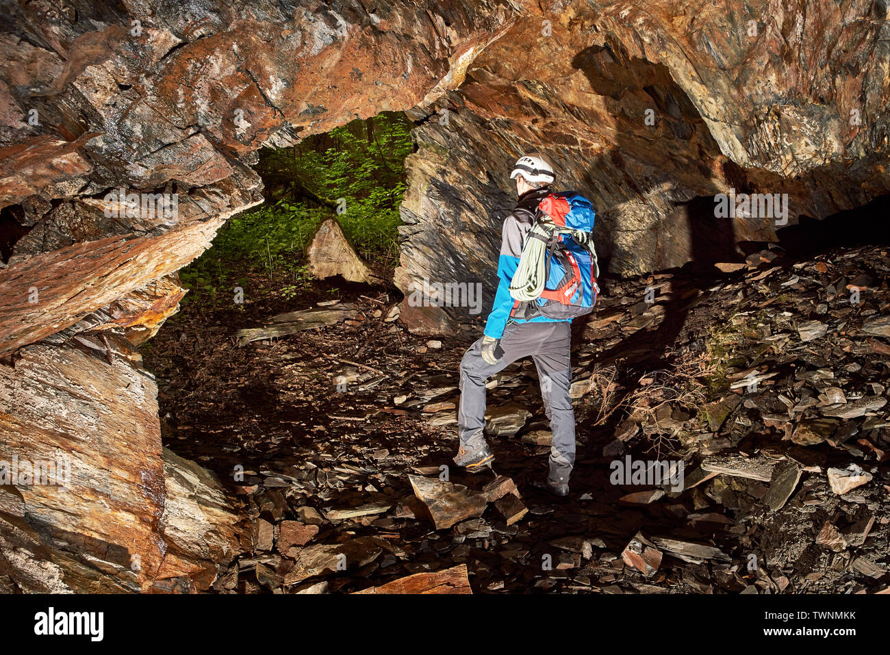 Young speleologist exploring a cave Stock Photo