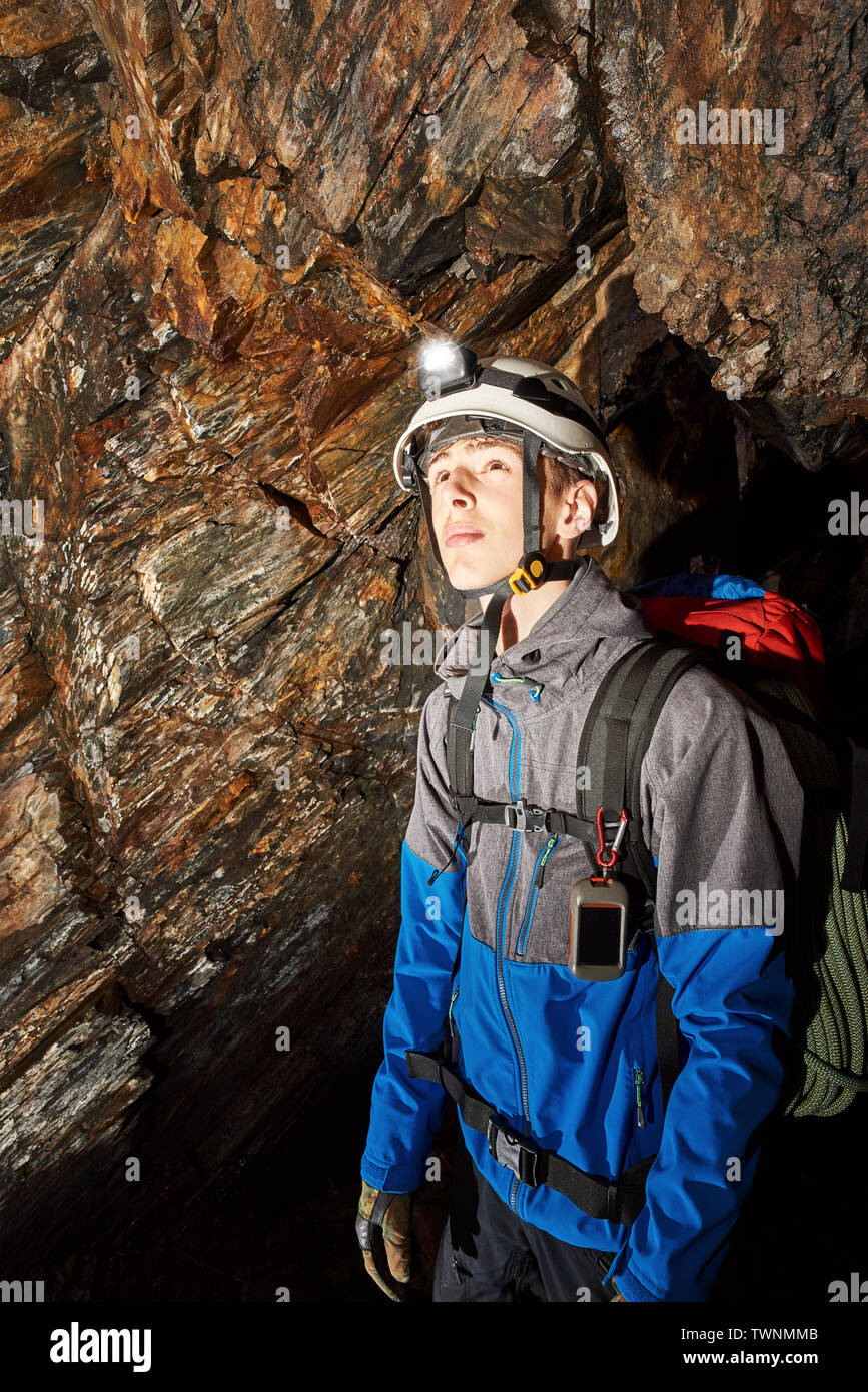 Young speleologist exploring a cave Stock Photo