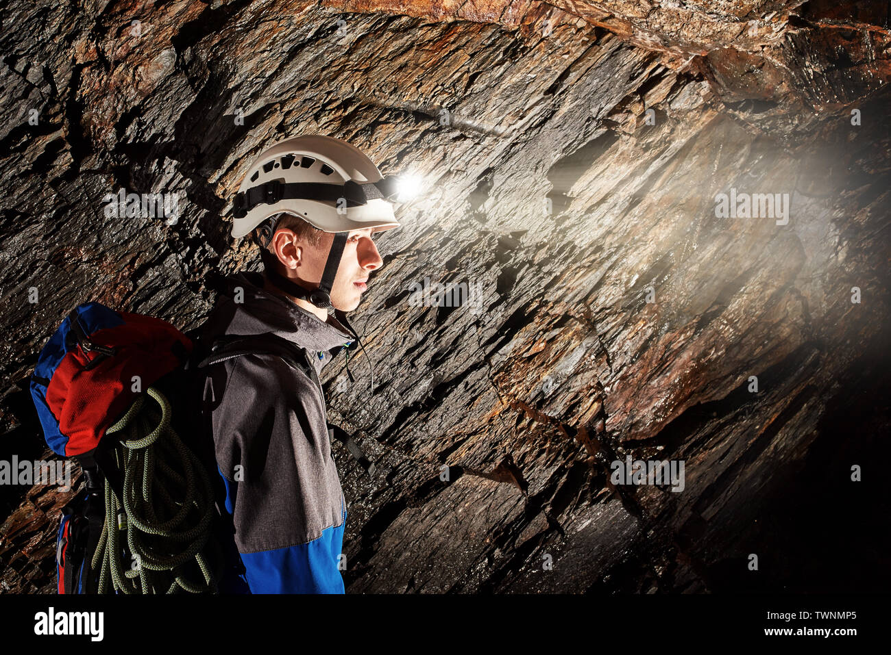 Young speleologist exploring a cave Stock Photo