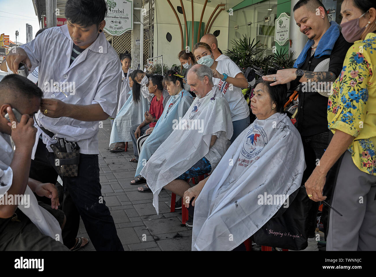 Street haircut. Business promotion of a local Thailand hair salon with people getting a free haircut Stock Photo