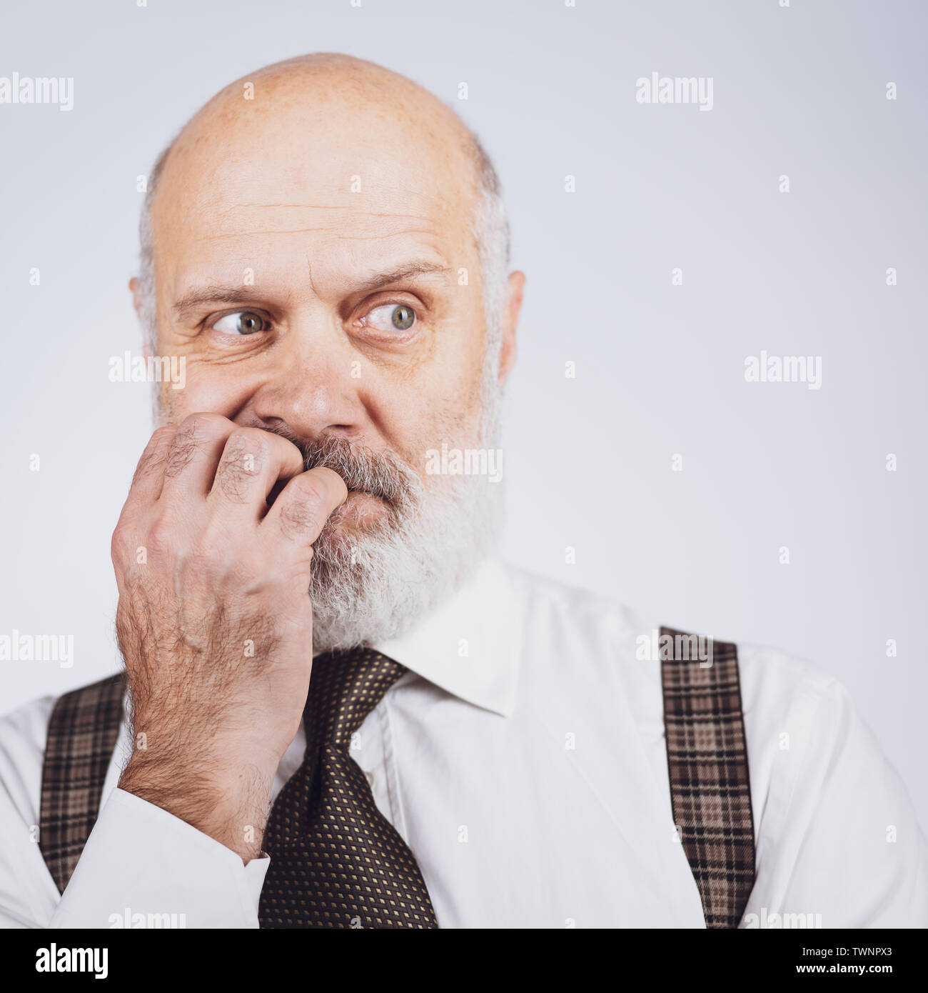 Nervous anxious senior business man biting his nails, he is scared and worried Stock Photo