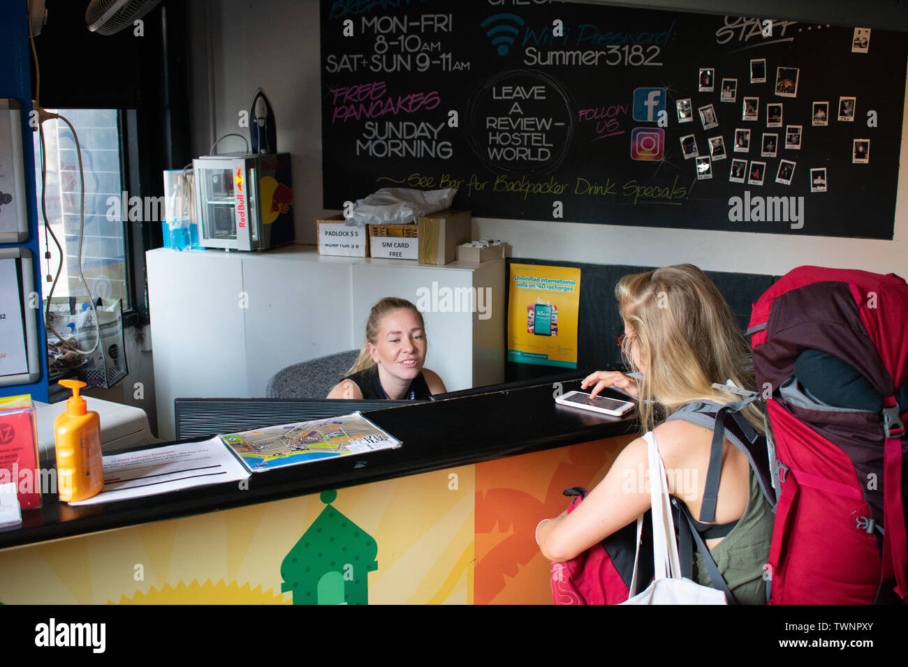Backpacker checking into reception at hostel in melbourne australia