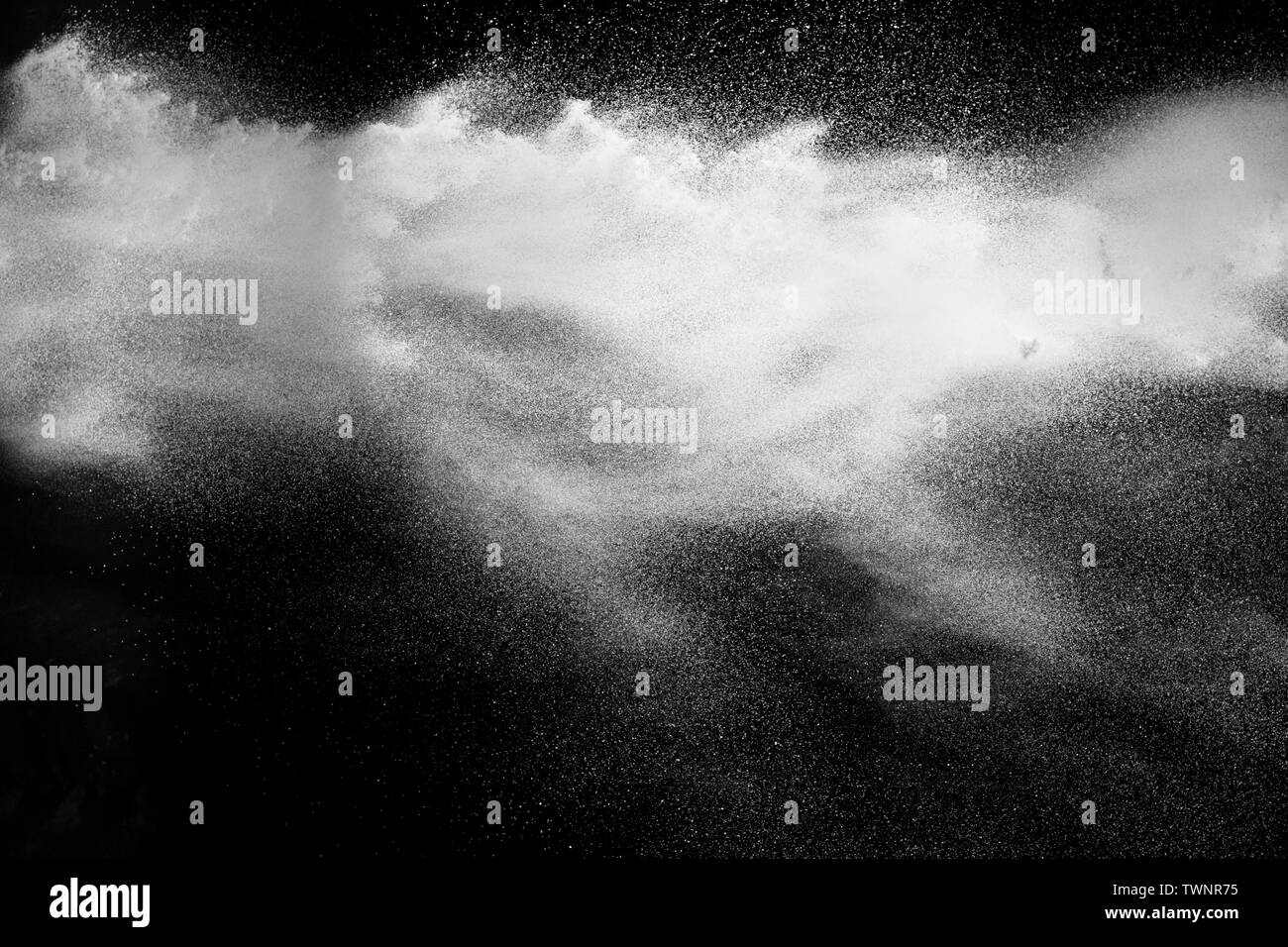 Freeze motion explosion of white powder on a black background.Stopping the movement of white dust on dark background. Stock Photo