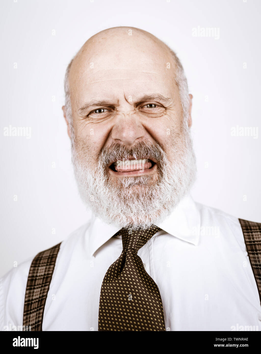 Disgusted funny senior man looking at camera, white background Stock Photo