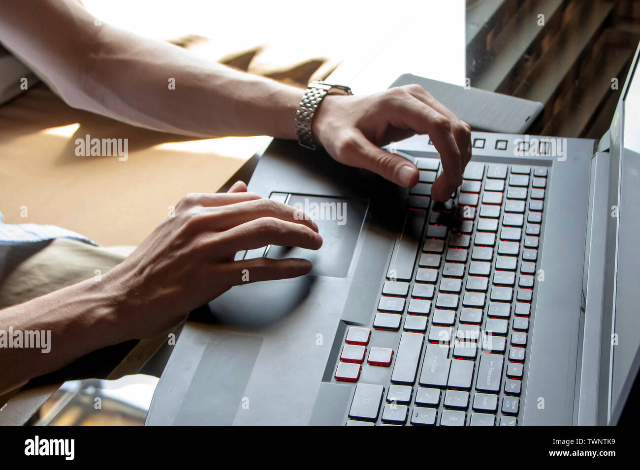Man working on his laptop with mobile phone Stock Photo