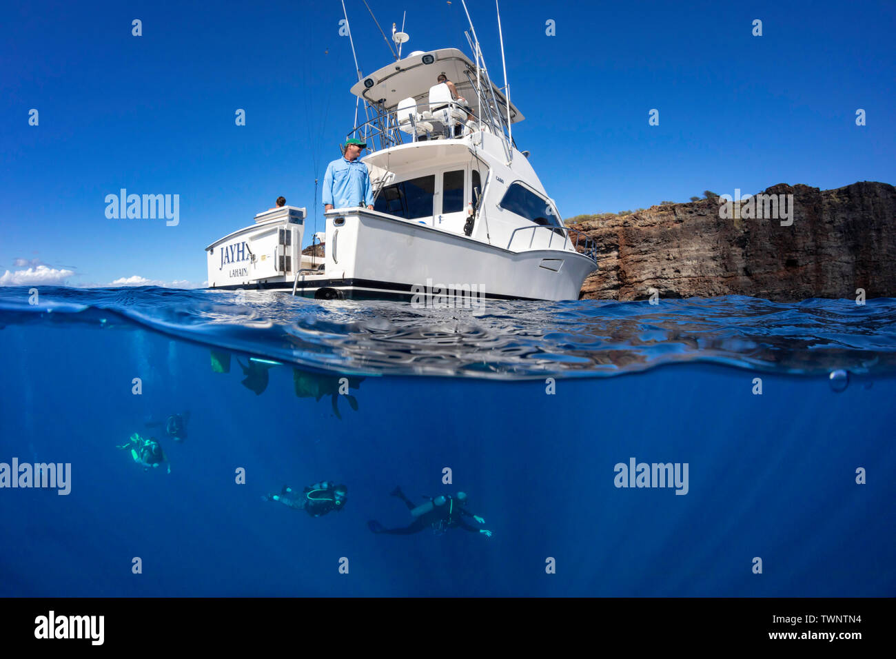 A split image of a group of divers (MR) returning to The Jayhawk, a charter boat based in Lahaina, Maui. It is pictured here in an area off the backsi Stock Photo
