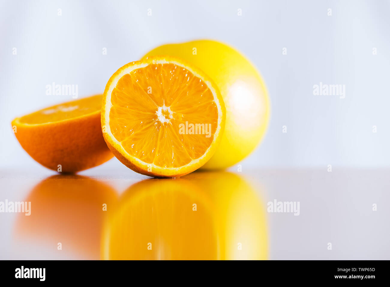 Fresh oranges on reflective wooden table Stock Photo