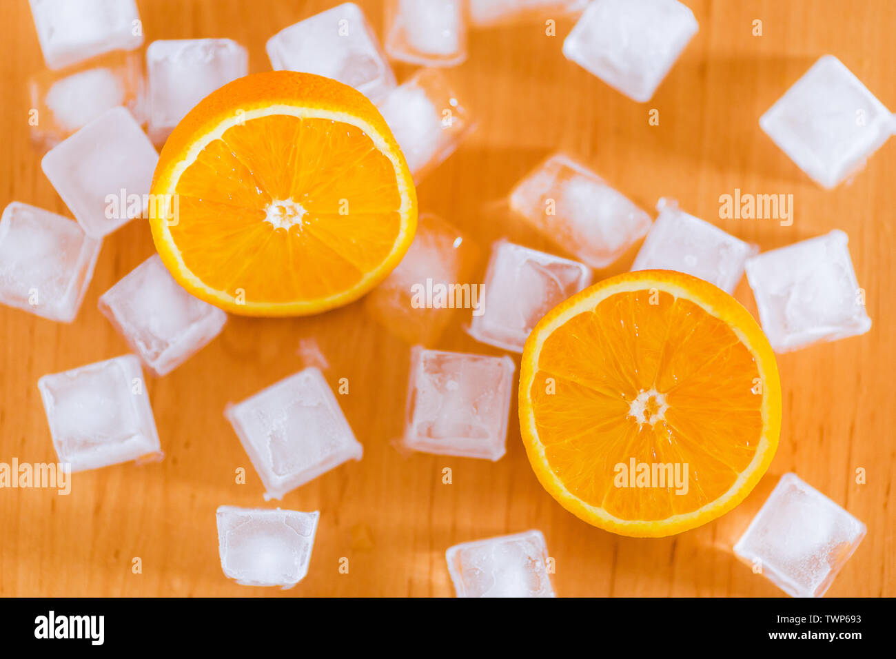 Fresh oranges and ice cubes wooden table, top view Stock Photo