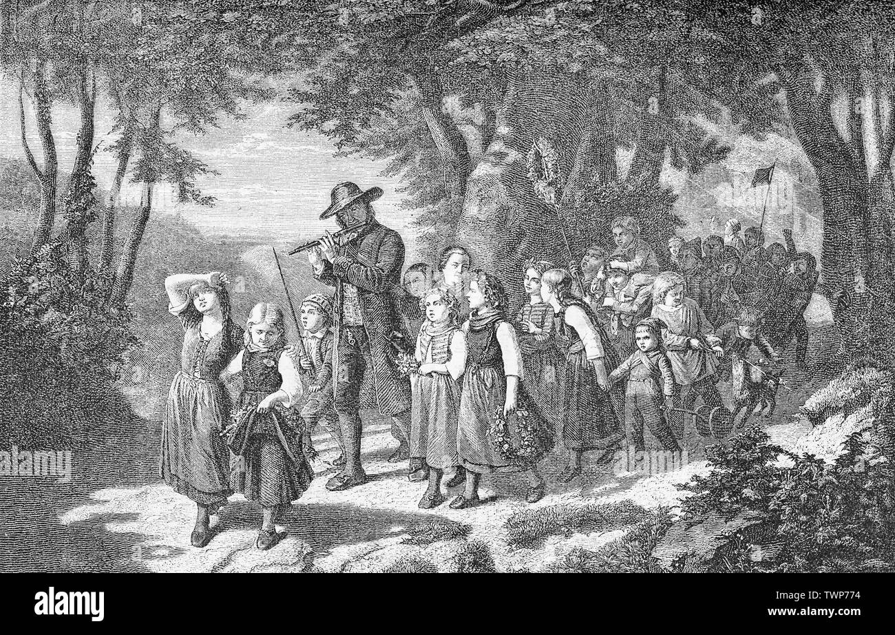 Rural May Day festive procession in the woods of children accompanied by the music of a pied-piper. May Day (May the first) is an ancient festival to welcome the spring weather and to drive away evil spirits Stock Photo