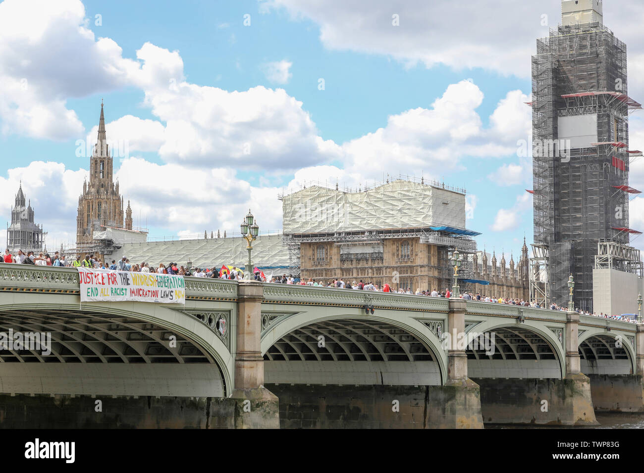 Westminster Bridge, London, UK. 22nd June, 2019. A banner drop from Westminster Bridge as part of the National Windrush Day of Action calling for justice and full compensation for victims of the Windrush scandal. Credit: Penelope Barritt/Alamy Live News Stock Photo
