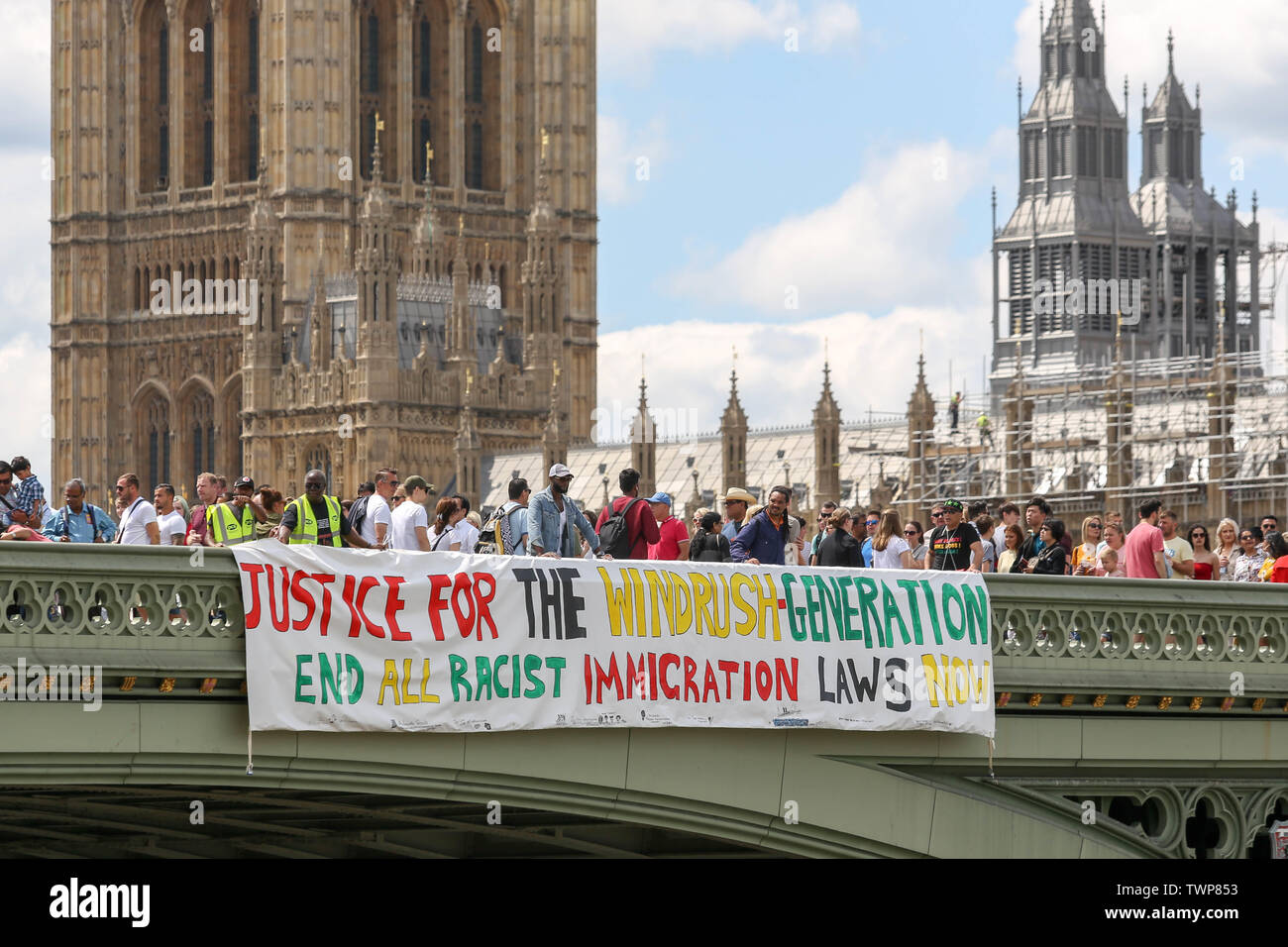 Westminster Bridge, London, UK. 22nd June, 2019. A banner drop from Westminster Bridge as part of the National Windrush Day of Action calling for justice and full compensation for victims of the Windrush scandal. Credit: Penelope Barritt/Alamy Live News Stock Photo