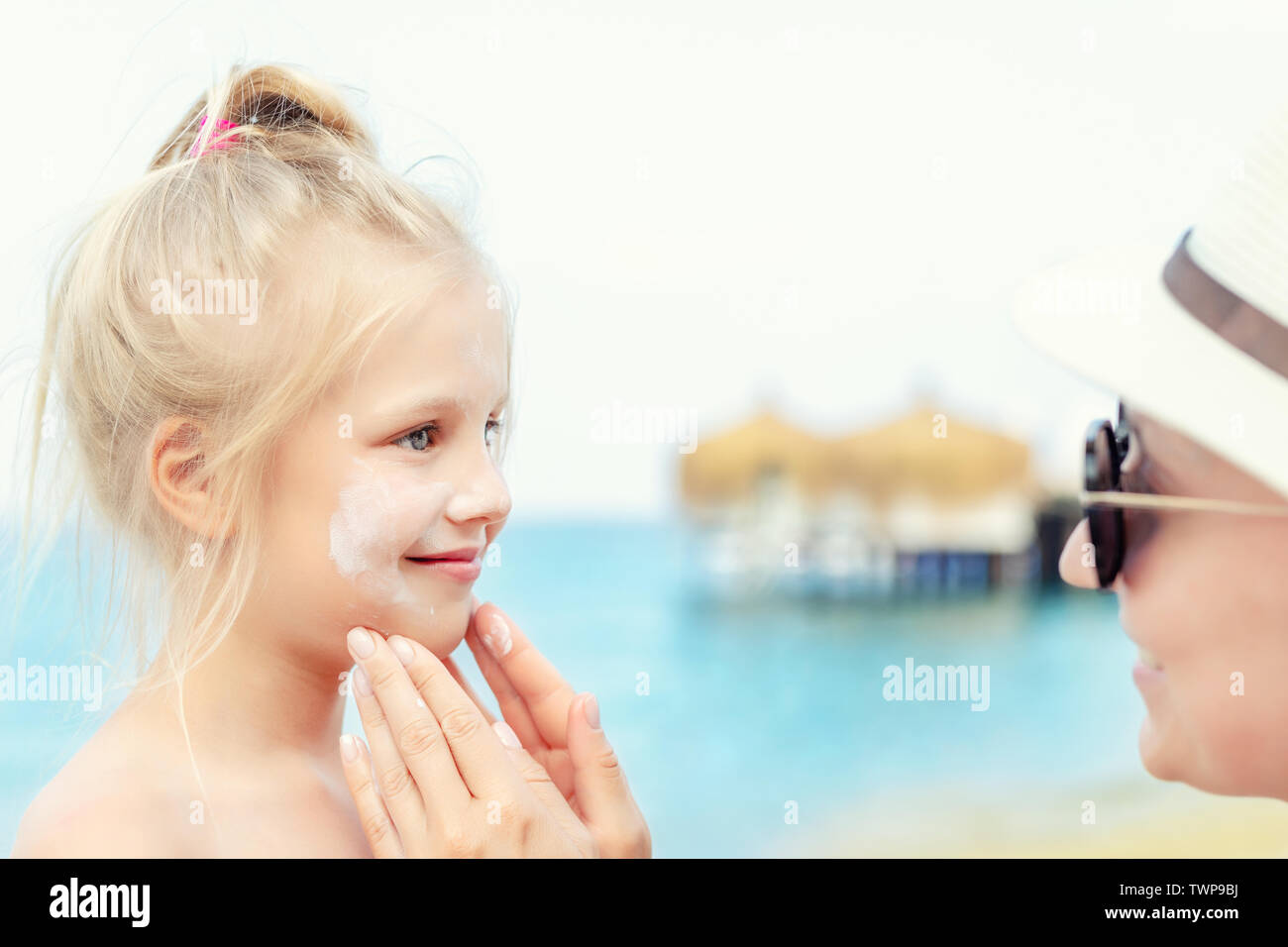 Mother applying sunscreen protection creme on cute little toddler boy