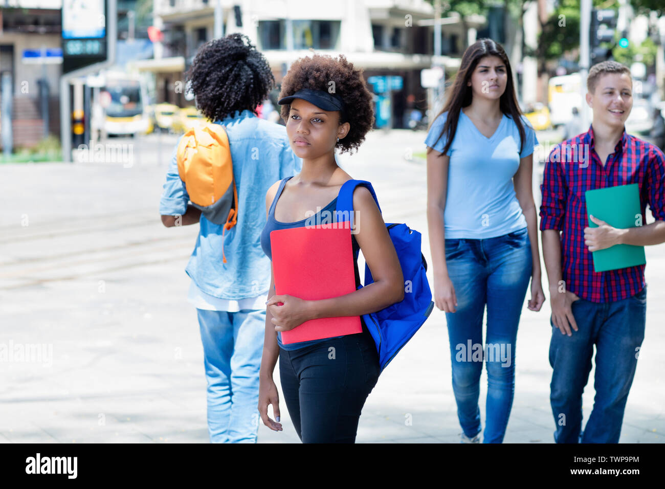 African american female student waiting for bus outdoors in city in summer Stock Photo