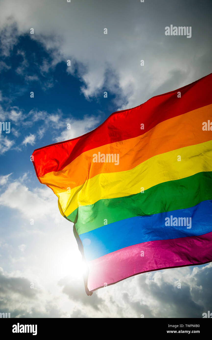 Close-up of gay pride rainbow flag fluttering backlit in bright sunny ...