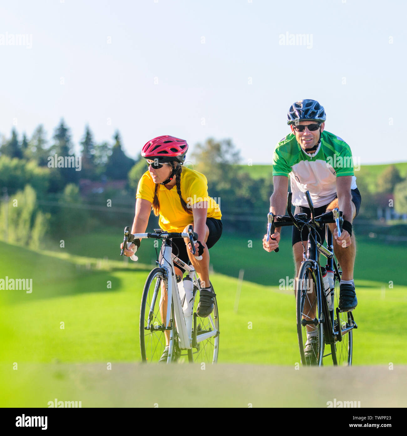 Couple doing a cycling tour on race bike at a sunny afternoon in bavarian Allgäu Stock Photo