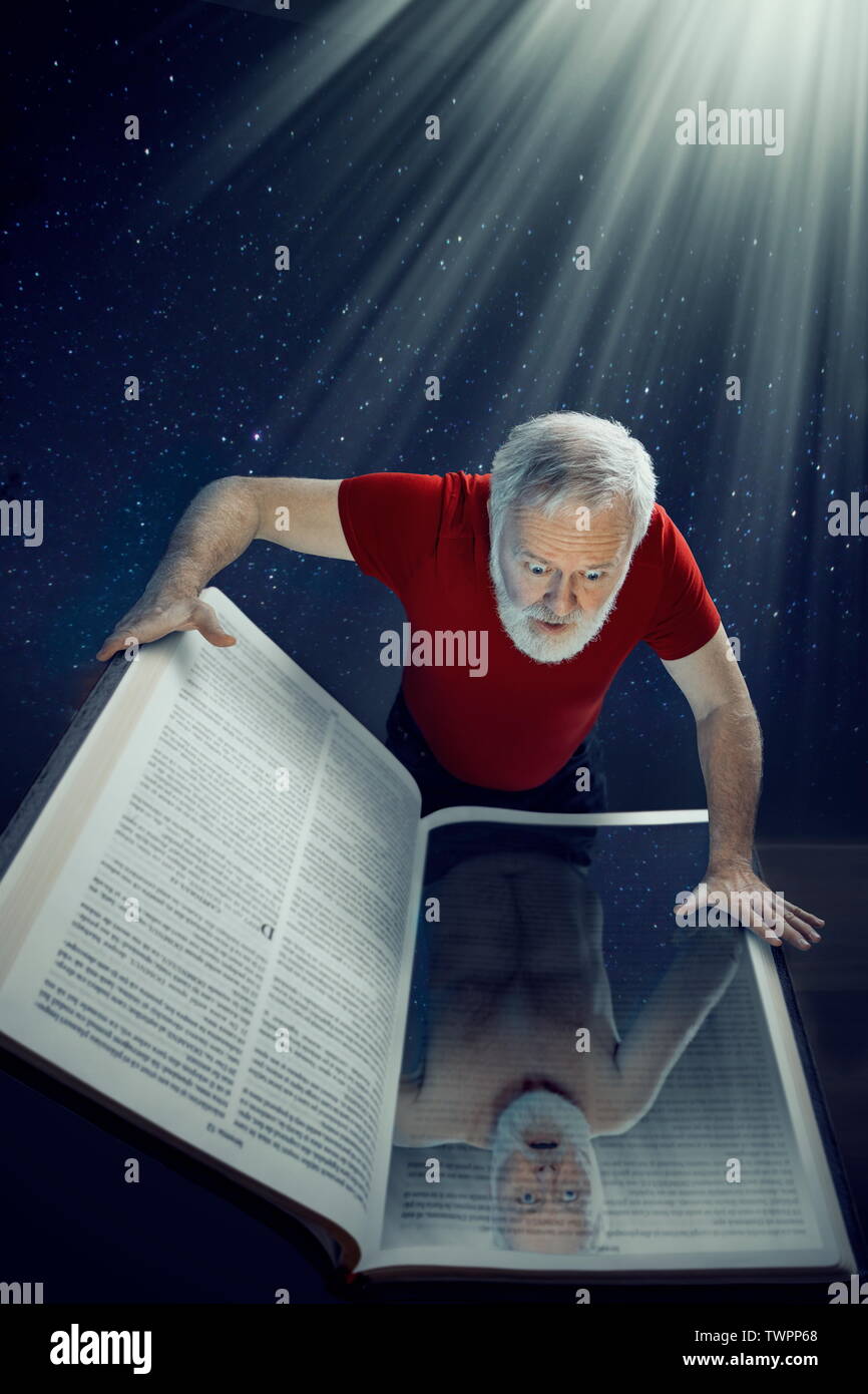 A mature man looking into the Holy Bible and seeing himself as he is, undressed by outside things. Stock Photo