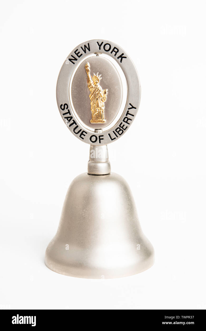 A close-up studio shot of a commemorative collectible tiny gift shop bell for tourists featuring New York City's iconic Statue of Liberty. Stock Photo