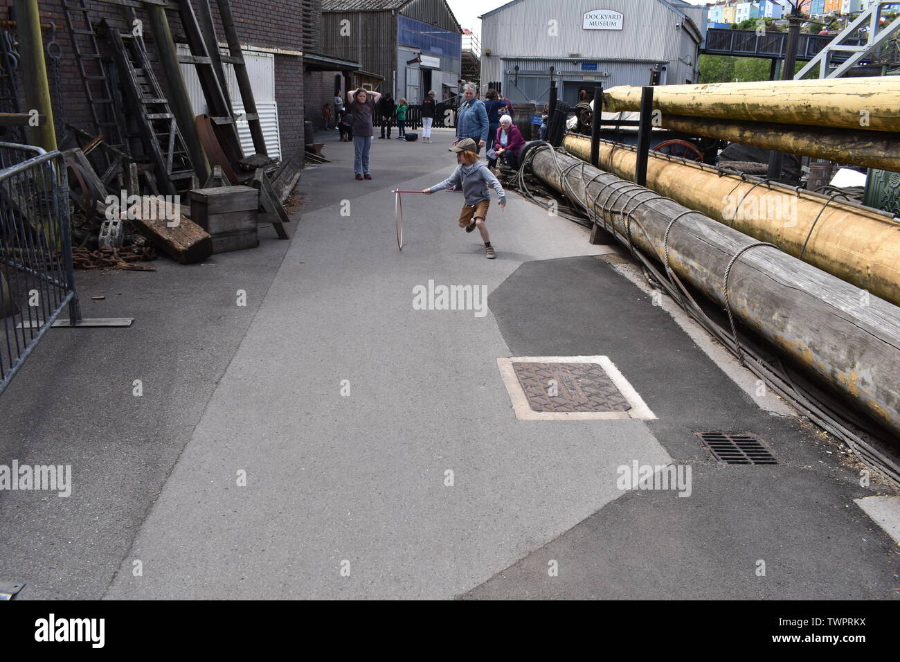 Boy playing stick and hoop at the SS Great Britain museum, Bristol, England Stock Photo