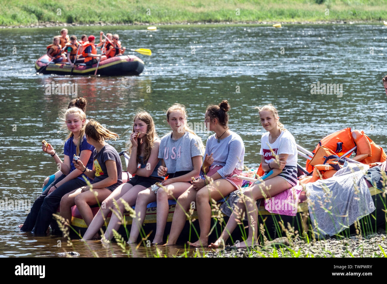 A group of girls and boys rafting river, boats, going down the Elbe River Germany, Saxon Switzerland National Park, Saxony teenagers Stock Photo