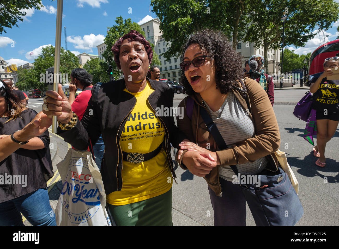 London, UK. 22nd June 2019. Eulalee a Jamaican Grandmother who was detained in Yarls Wood and Antonia from Movement for Justice outside Downing St as 7 UK cities take part in the National Windrush Day of Action calling for justice and full compensation for victims of the Windrush scandal, their multi-generation families and other communities targeted under the hostile environment for detention and deportation. After a rally at Downing St they marched to Westminster Bridge to lower banners over it and then block the road for some final speeches. Peter Marshall/Alamy Live News Credit: Peter Mars Stock Photo