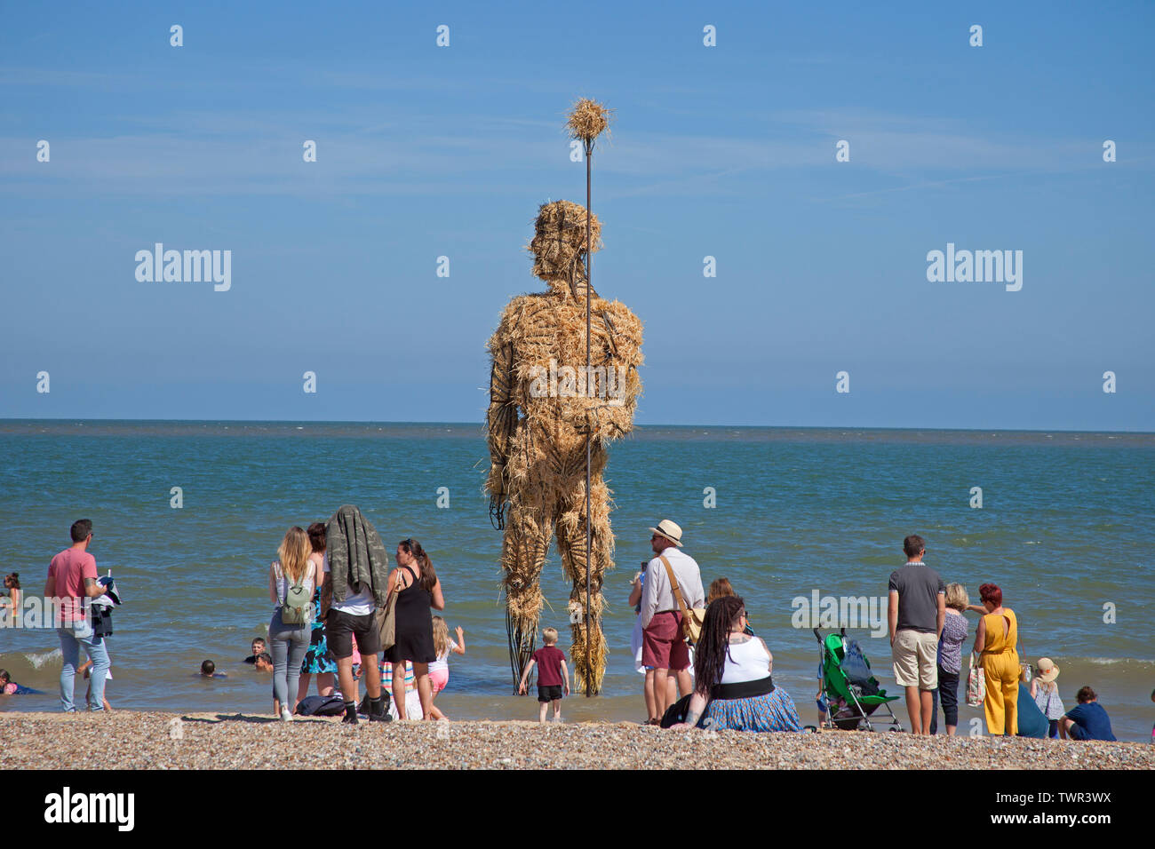 22nd June 2019. Lowestoft, England, UK. Lowestoft's First Light Festival, crowds gather on South Beach with temperatures of over 20 degrees with beautiful blue skies. Festival runs for 24 hours non-stop until 12 pm on Sunday. Visitors look at the straw Pakefield Man'. Arts charity FlipSide are delivering the festival in partnership with Hemingway Design. Visitors look at the straw Pakefield Man'. Stock Photo