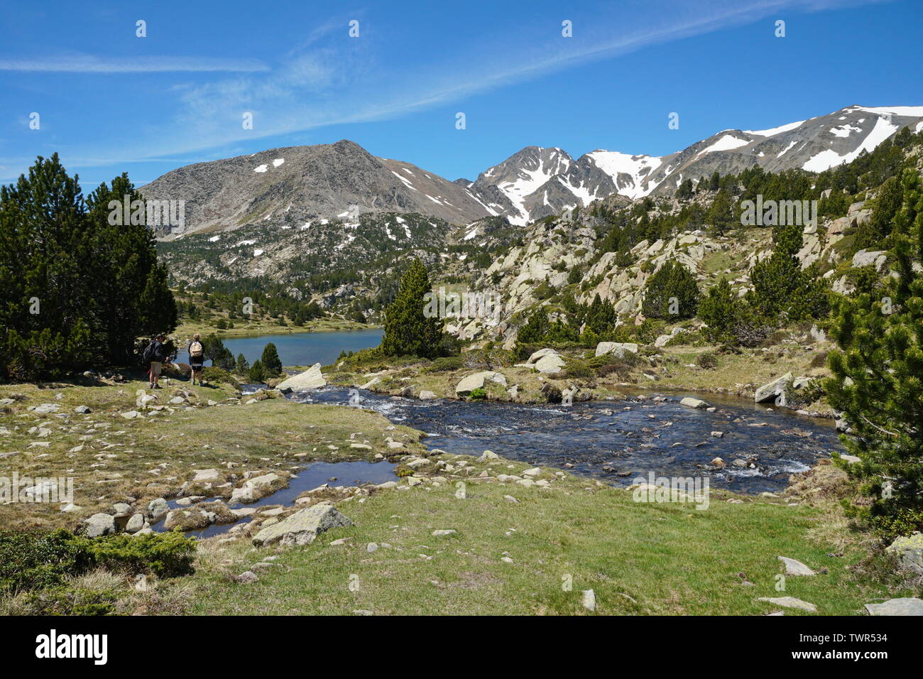 France Pyrenees-Orientales mountain landscape, stream and Comassa lake with Carlit massif in background, natural park of the Catalan Pyrenees Stock Photo