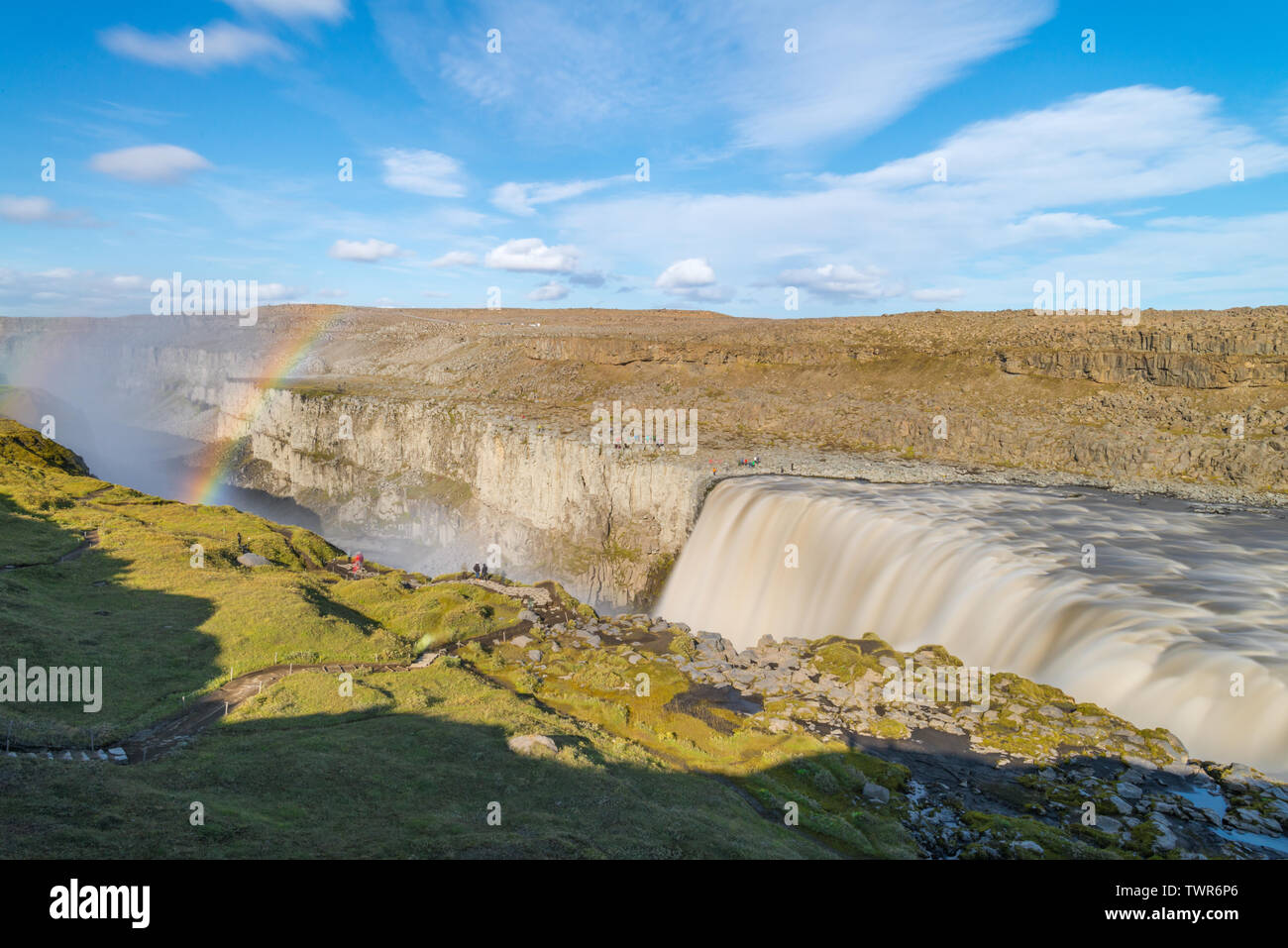 Long exposure of Dettifoss falls in Iceland. Famous tourist attraction Dettifoss, powerful waterfall and deep canyon covered in mist and rainbow. Stock Photo