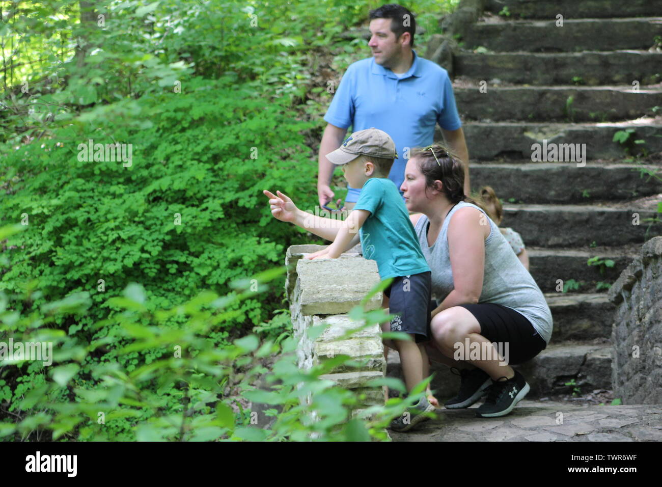 Family or four exploring a small stone bridge located in a county park in South Eastern Wisconsin in June of 2019. Stock Photo