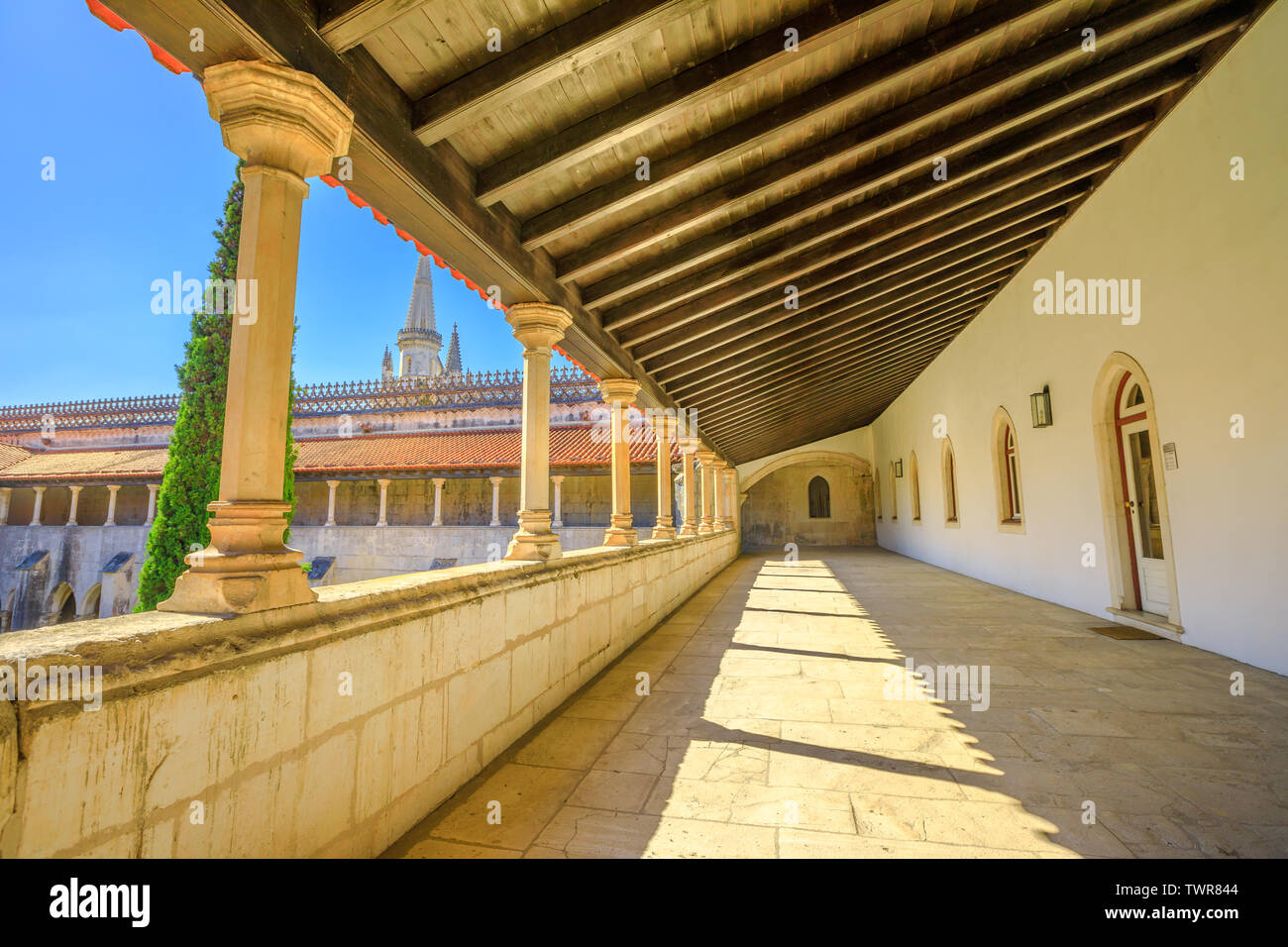 Batalha, Portugal - August 16, 2017: corridor of Batalha Monastery and Church and gothic tower on background. Monastery of Saint Mary of the Victory Stock Photo