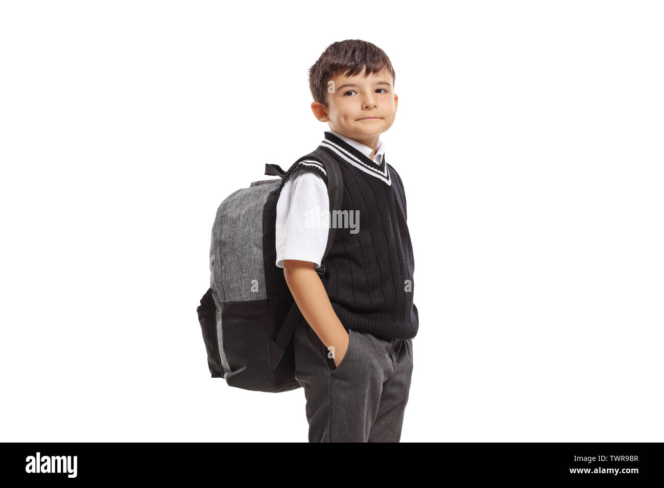 Schoolboy in a uniform with a backpack looking at the camera isolated ...
