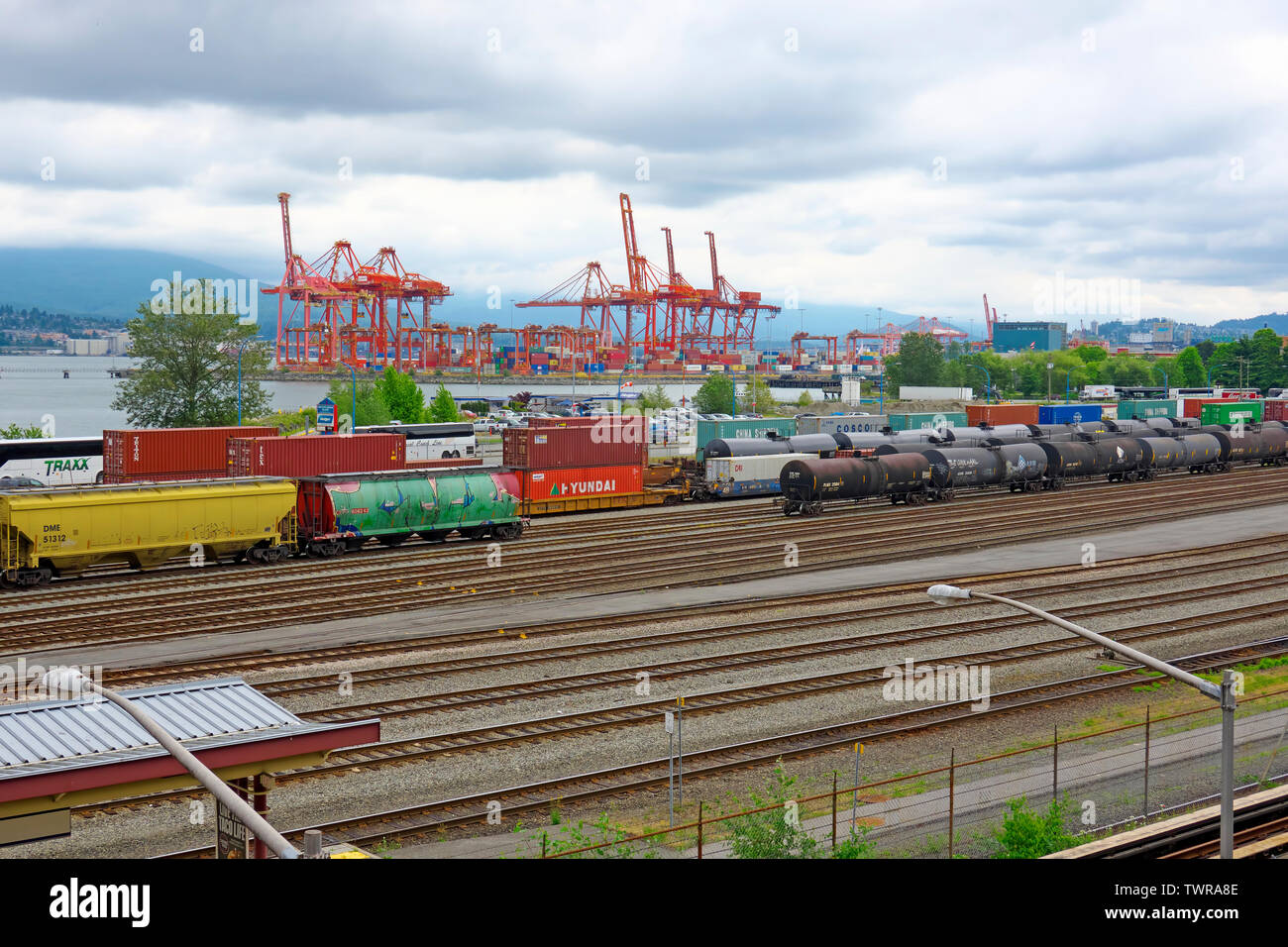 Shipping Containers at Canada Place Cruise Ship Terminal and Freight Trains Along Railroad Tracks in Vancouver, B. C. Stock Photo