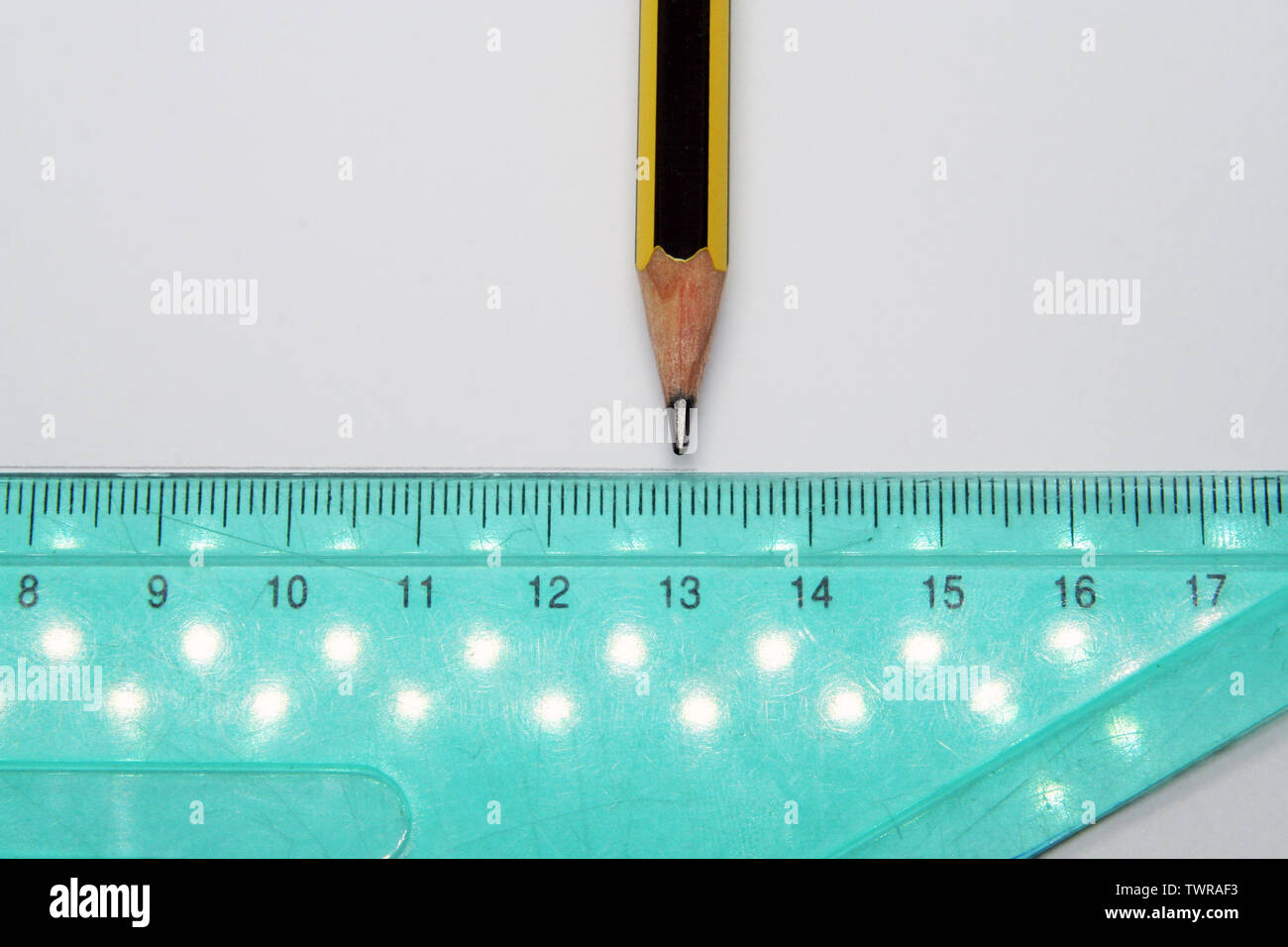 Old used triangle ruler and a pencil. Ruler and pencil. Stock Photo