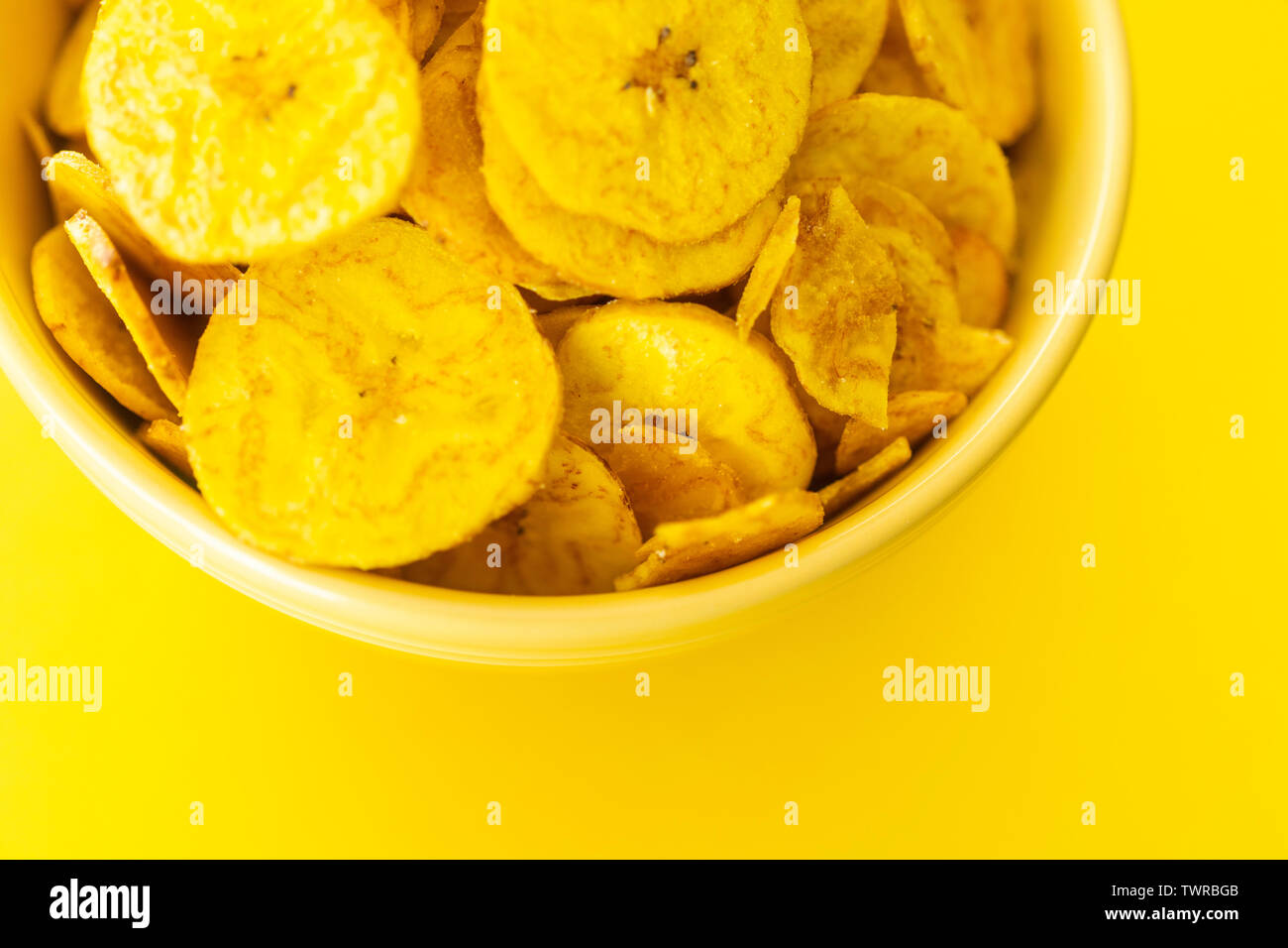 Baked Plantain Chips in Yellow bowl - a healthy snack Stock Photo