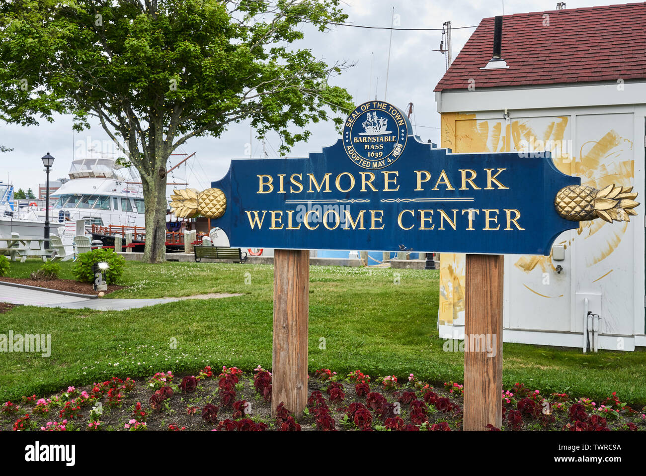 Hyannis, MA - June 10, 2019: Welcome sign in Bismore park has gold pineapples on each end and the Seal of the Town of Barnstable Massachusetts. Hyanni Stock Photo
