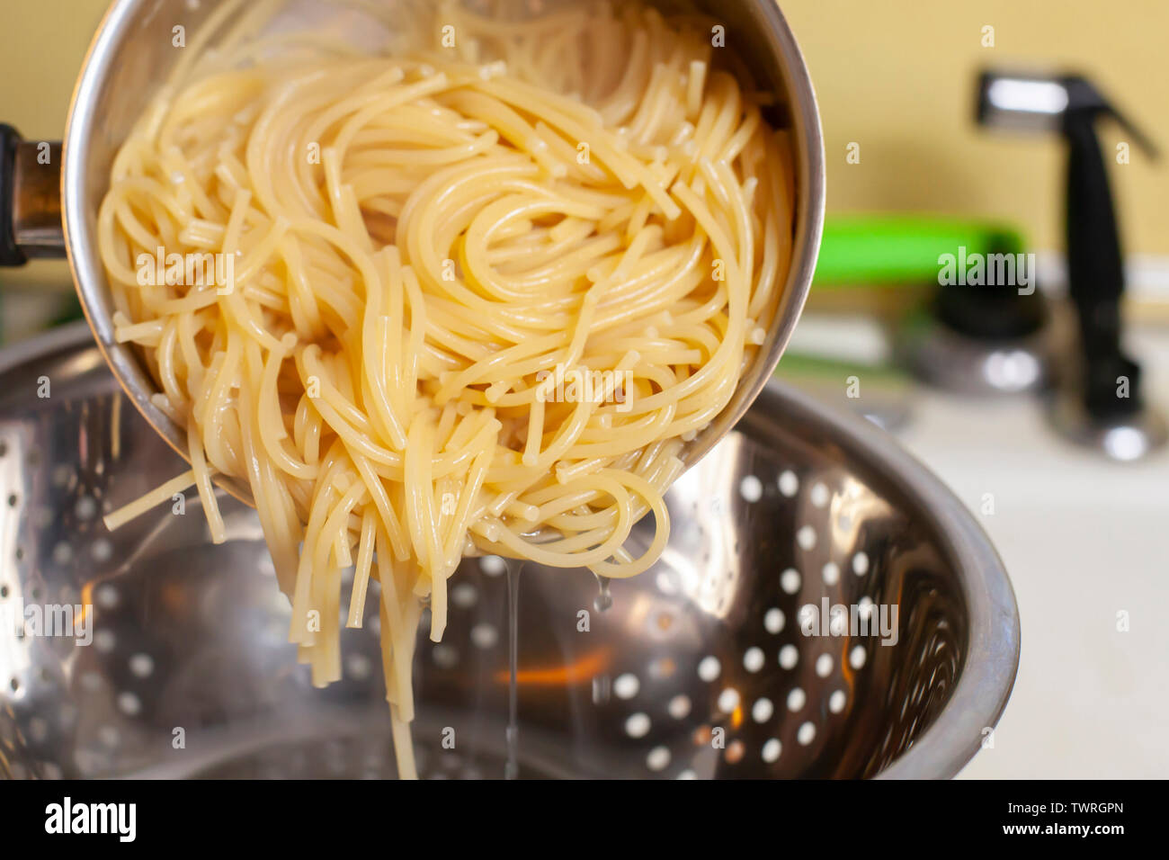 Preparing to drain cooked spaghetti in a sink Stock Photo Alamy